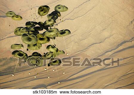 Picture - Pallets of cargo dropping from a C-17 Globemaster III to a forward operating base in Afghanistan.. Fotosearch