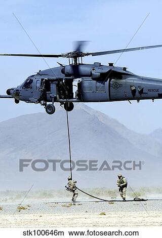 Pararescuemen descend from an HH-60 Pave Hawk helicopter. View Large Photo Image Picture - Pararescuemen descend from an HH-60 Pave Hawk helicopter.. Fotosearch