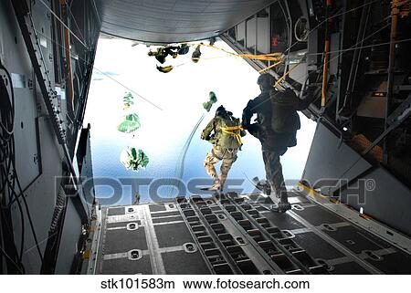 Pararescuemen perform a static-line jump out of a C-130 Hercules. View Large Photo Image Picture - Pararescuemen perform a static-line jump out of a C-130 Hercules.. Fotosearch