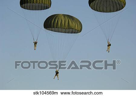 Paratroopers descend through the sky. View Large Photo Image Picture - Paratroopers descend through the sky.. Fotosearch