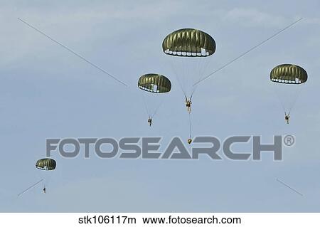 Paratroopers descend through the sky. View Large Photo Image Picture - Paratroopers descend through the sky.. Fotosearch