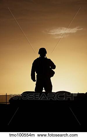 Picture - Partially silhouetted U. S. Marine on a bunker in Afghanistan.. Fotosearch