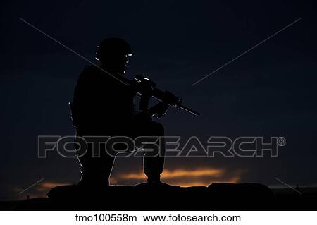 Picture - Partially silhouetted U. S. Marine on a bunker in Afghanistan.. Fotosearch