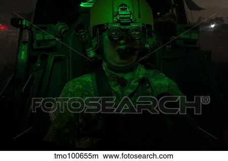 Pilot equipped with night vision goggles in the cockpit of an Apache helicopter. View Large Photo Image Picture - Pilot equipped with night vision goggles in the cockpit of an Apache helicopter.. Fotosearch