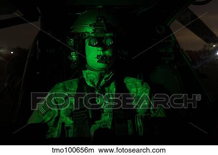 Pilot equipped with night vision goggles in the cockpit of an Apache helicopter. View Large Photo Image Picture - Pilot equipped with night vision goggles in the cockpit of an Apache helicopter.. Fotosearch