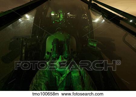 Pilot equipped with night vision goggles in the cockpit of an Apache helicopter. View Large Photo Image Picture - Pilot equipped with night vision goggles in the cockpit of an Apache helicopter.. Fotosearch