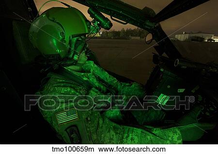 Pilot equipped with night vision goggles in the cockpit of an Apache helicopter. View Large Photo Image Picture - Pilot equipped with night vision goggles in the cockpit of an Apache helicopter.. Fotosearch