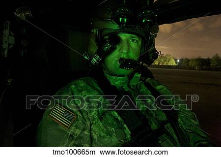 Pilot equipped with night vision goggles in the cockpit of an Apache helicopter. View Large Photo Image Picture - Pilot equipped with night vision goggles in the cockpit of an Apache helicopter.. Fotosearch