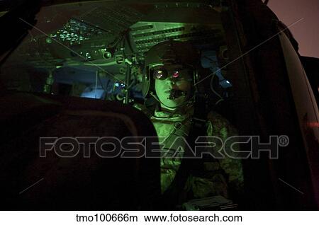Pilot equipped with night vision goggles in the cockpit of a UH-60 Blackhawk View Large Photo Image Picture - Pilot equipped with night vision goggles in the cockpit of a UH-60 Blackhawk. Fotosearch