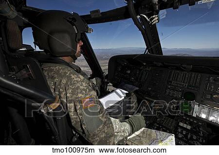 Pilot operating the cockpit of a UH-60 Black Hawk helicopter. View Large Photo Image Picture - Pilot operating the cockpit of a UH-60 Black Hawk helicopter.. Fotosearch