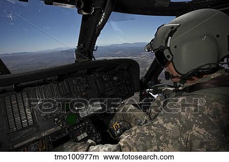 Pilot operating the cockpit of a UH-60 Black Hawk helicopter. View Large Photo Image Picture - Pilot operating the cockpit of a UH-60 Black Hawk helicopter.. Fotosearch
