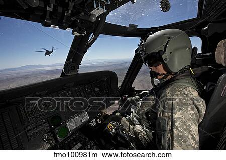 Picture - Pilot operating the cockpit of a UH-60 Black Hawk helicopter.. Fotosearch