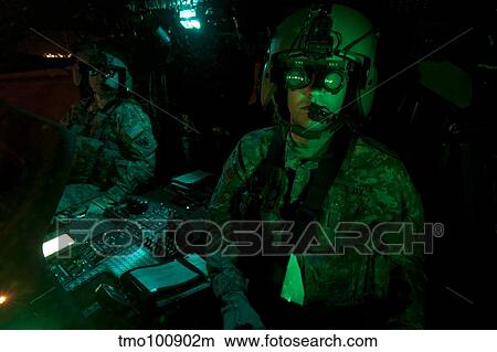 Pilots equipped with night vision goggles in the cockpit of a UH-60 Black Hawk. View Large Photo Image Picture - Pilots equipped with night vision goggles in the cockpit of a UH-60 Black Hawk.. Fotosearch