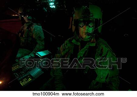 Pilots equipped with night vision goggles in the cockpit of a UH-60 Black Hawk. View Large Photo Image Picture - Pilots equipped with night vision goggles in the cockpit of a UH-60 Black Hawk.. Fotosearch