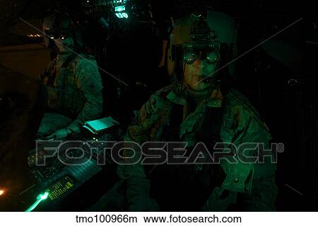 Pilots equipped with night vision goggles in the cockpit of a UH-60 Black Hawk. View Large Photo Image Picture - Pilots equipped with night vision goggles in the cockpit of a UH-60 Black Hawk.. Fotosearch