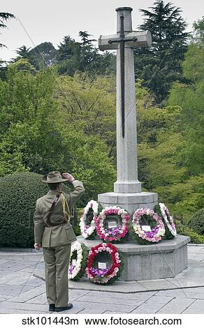 Representative of the Australian Defense Force salutes a cross after laying a wreath. View Large Photo Image Picture - Representative of the Australian Defense Force salutes a cross after laying a wreath.. Fotosearch