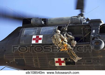 Royal Australian Air Force Aircraftman is hoisted onto a UH-60 Black Hawk. View Large Photo Image Picture - Royal Australian Air Force Aircraftman is hoisted onto a UH-60 Black Hawk.. Fotosearch