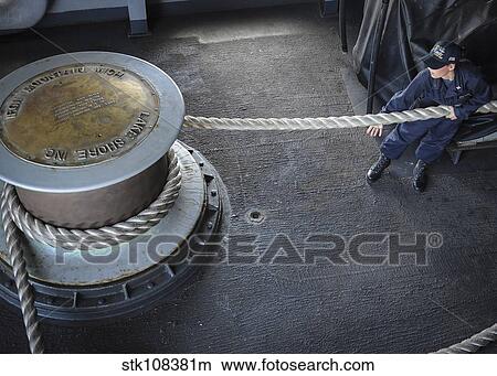 Sailor pulls a line around the capstan on the fantail of USS Nimitz. View Large Photo Image Picture - Sailor pulls a line around the capstan on the fantail of USS Nimitz.. Fotosearch