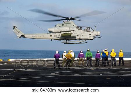 Sailors and Marines watch an AH-1Z Viper attack helicopter lift off the flight deck of USS New Orleands. View Large Photo Image Picture - Sailors and Marines watch an AH-1Z Viper attack helicopter lift off the flight deck of USS New Orleands.. Fotosearch