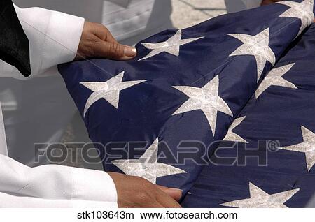 Sailors assigned to the colors detail fold the national ensign. View Large Photo Image Picture - Sailors assigned to the colors detail fold the national ensign.. Fotosearch