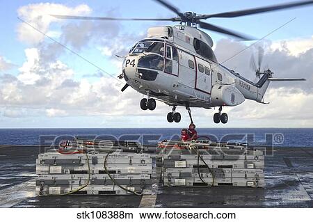 Sailors attach cargo legs to an SA330J Puma helicopter. View Large Photo Image Picture - Sailors attach cargo legs to an SA330J Puma helicopter.. Fotosearch