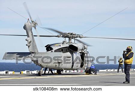Sailors chock and chain an MH-60S Sea Hawk helicopter. View Large Photo Image Picture - Sailors chock and chain an MH-60S Sea Hawk helicopter.. Fotosearch