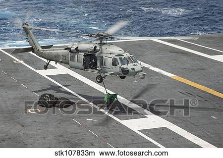 Sailors connect cargo legs and nets to an MH-60S Sea Hawk. View Large Photo Image Picture - Sailors connect cargo legs and nets to an MH-60S Sea Hawk.. Fotosearch