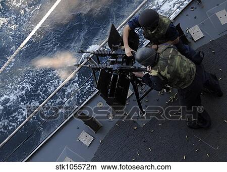 Picture - Sailors fire a dual-mounted M240 machine gun aboard USS Bunker Hill.. Fotosearch