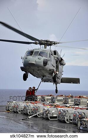 Sailors hook an ammunition pallet to an MH-60S Sea Hawk helicopter. View Large Photo Image Picture - Sailors hook an ammunition pallet to an MH-60S Sea Hawk helicopter.. Fotosearch