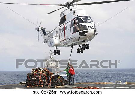 Sailors hook up a pole pendant to a SA-330J Puma helicopter. View Large Photo Image Picture - Sailors hook up a pole pendant to a SA-330J Puma helicopter.. Fotosearch