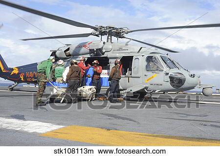 Sailors load fresh water onto an MH-60S Seahawk. View Large Photo Image Picture - Sailors load fresh water onto an MH-60S Seahawk.. Fotosearch