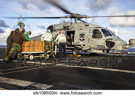Sailors load relief supplies onto an MH-60S Sea Hawk. View Large Photo Image Picture - Sailors load relief supplies onto an MH-60S Sea Hawk.. Fotosearch