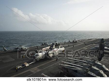 Sailors move a C-2A Greyhound across the flight deck of USS Nimitz. View Large Photo Image Picture - Sailors move a C-2A Greyhound across the flight deck of USS Nimitz.. Fotosearch