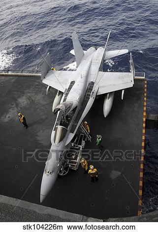 Sailors move an F/A-18C Hornet into the hangar bay. View Large Photo Image Picture - Sailors move an F/A-18C Hornet into the hangar bay.. Fotosearch