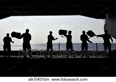 Sailors pass supplies to each other in the hangar bay of USS Ronald Reagan. View Large Photo Image Picture - Sailors pass supplies to each other in the hangar bay of USS Ronald Reagan.. Fotosearch