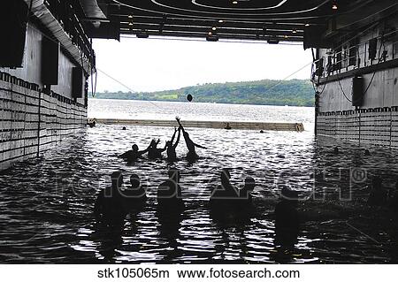 Sailors play football during a swim call in the well deck of USS Cleveland. View Large Photo Image Picture - Sailors play football during a swim call in the well deck of USS Cleveland.. Fotosearch