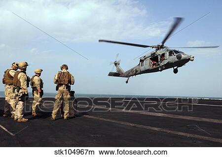 Sailors prepare to board an MH-60S Sea Hawk helicopter. View Large Photo Image Picture - Sailors prepare to board an MH-60S Sea Hawk helicopter.. Fotosearch