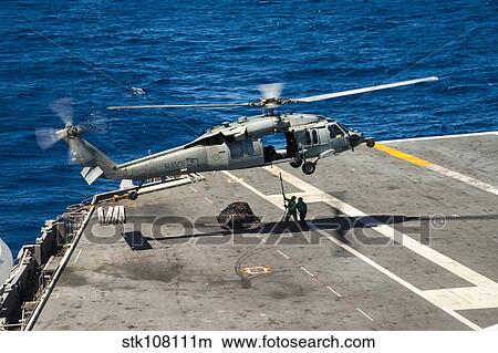 Sailors prepare to connect cargo legs and nets to an MH-60S Sea Hawk. View Large Photo Image Picture - Sailors prepare to connect cargo legs and nets to an MH-60S Sea Hawk.. Fotosearch