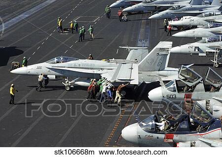 Sailors push an F/A-18C Hornet in preparation for flight operations. View Large Photo Image Picture - Sailors push an F/A-18C Hornet in preparation for flight operations.. Fotosearch