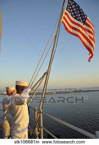 Sailors salute the national ensign aboard USS Bataan. View Large Photo Image Picture - Sailors salute the national ensign aboard USS Bataan.. Fotosearch