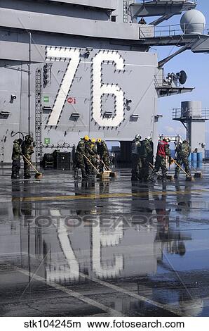 Sailors scrub the flight deck aboard the aircraft carrier USS Ronald Reagan. View Large Photo Image Picture - Sailors scrub the flight deck aboard the aircraft carrier USS Ronald Reagan.. Fotosearch