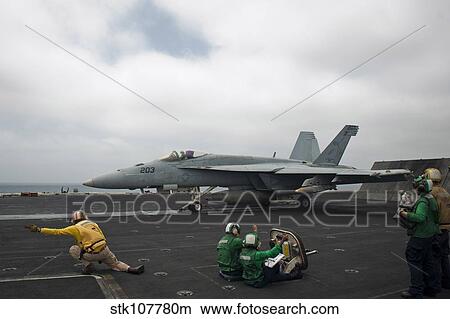 Picture - Sailors signal to launch an F/A-18E Super Hornet.. Fotosearch