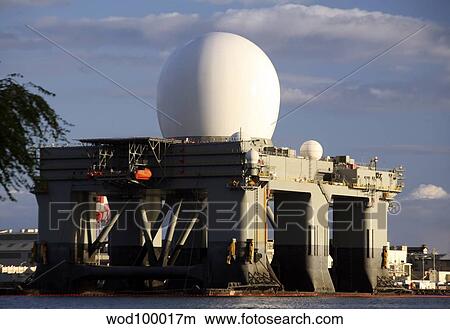 Sea Based X-band Radar dome modeled by the setting sun at Pearl Harbor naval shipyard. View Large Photo Image Picture - Sea Based X-band Radar dome modeled by the setting sun at Pearl Harbor naval shipyard.. Fotosearch