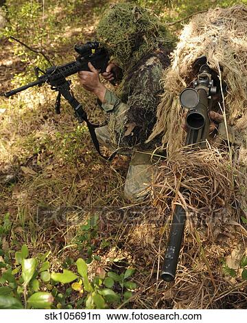 Sharpshooters sneak through the forest in their ghillie suits. View Large Photo Image Picture - Sharpshooters sneak through the forest in their ghillie suits.. Fotosearch