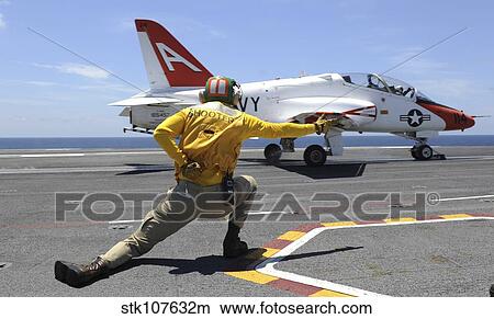 Shooter signals to a T-45C Goshawk as it launches from USS George H. W. Bush. View Large Photo Image Picture - Shooter signals to a T-45C Goshawk as it launches from USS George H. W. Bush.. Fotosearch