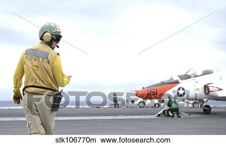 Shooter signals to the pilot of a T-45C Goshawk training aircraft. View Large Photo Image Picture - Shooter signals to the pilot of a T-45C Goshawk training aircraft.. Fotosearch