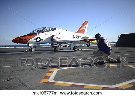 Shooter signals to the pilot of a T-45C Goshawk training aircraft. View Large Photo Image Picture - Shooter signals to the pilot of a T-45C Goshawk training aircraft.. Fotosearch