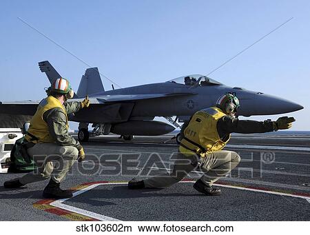 Shooters aboard the USS George H. W. Bush give the go-ahead signal to launch an F/A-18 Super Hornet. View Large Photo Image Picture - Shooters aboard the USS George H. W. Bush give the go-ahead signal to launch an F/A-18 Super Hornet.. Fotosearch