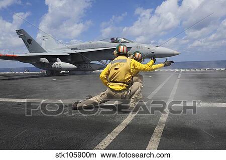 Shooters give the signal to launch an F/A-18C Hornet. View Large Photo Image Picture - Shooters give the signal to launch an F/A-18C Hornet.. Fotosearch