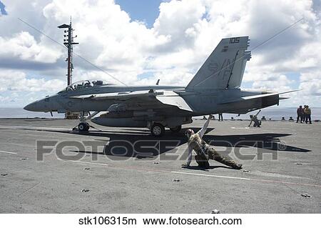 Shooters give the signal to launch an F/A-18E Super Hornet. View Large Photo Image Picture - Shooters give the signal to launch an F/A-18E Super Hornet.. Fotosearch